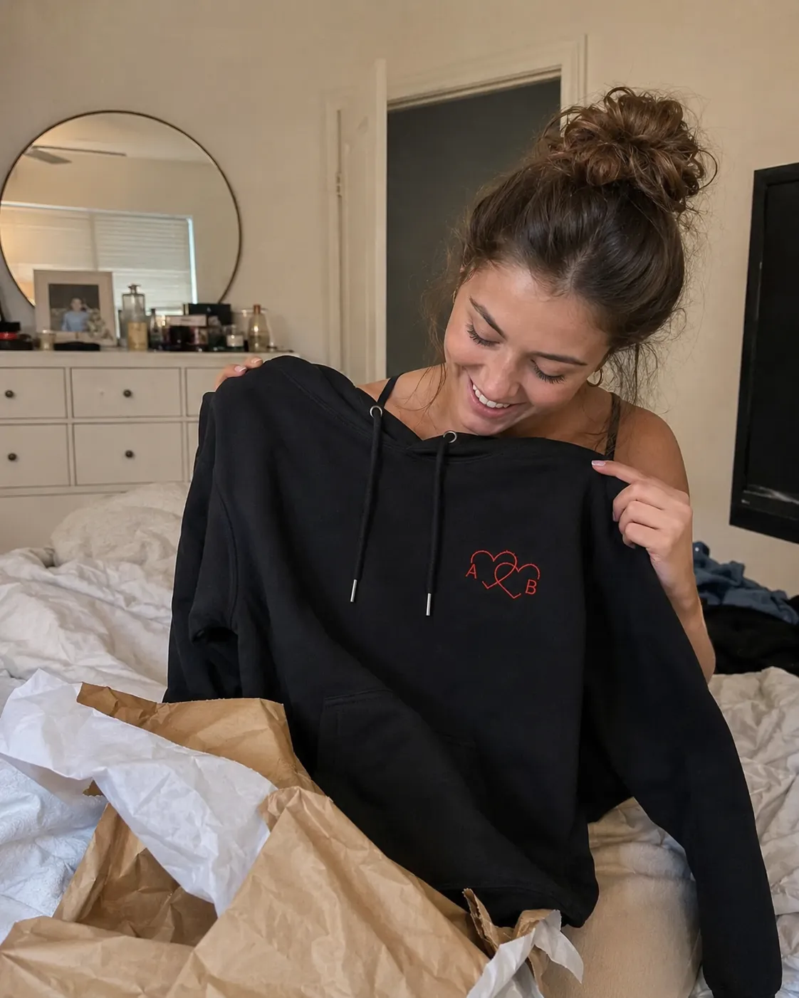 Sweats personnalisés brodés posés sur un lit